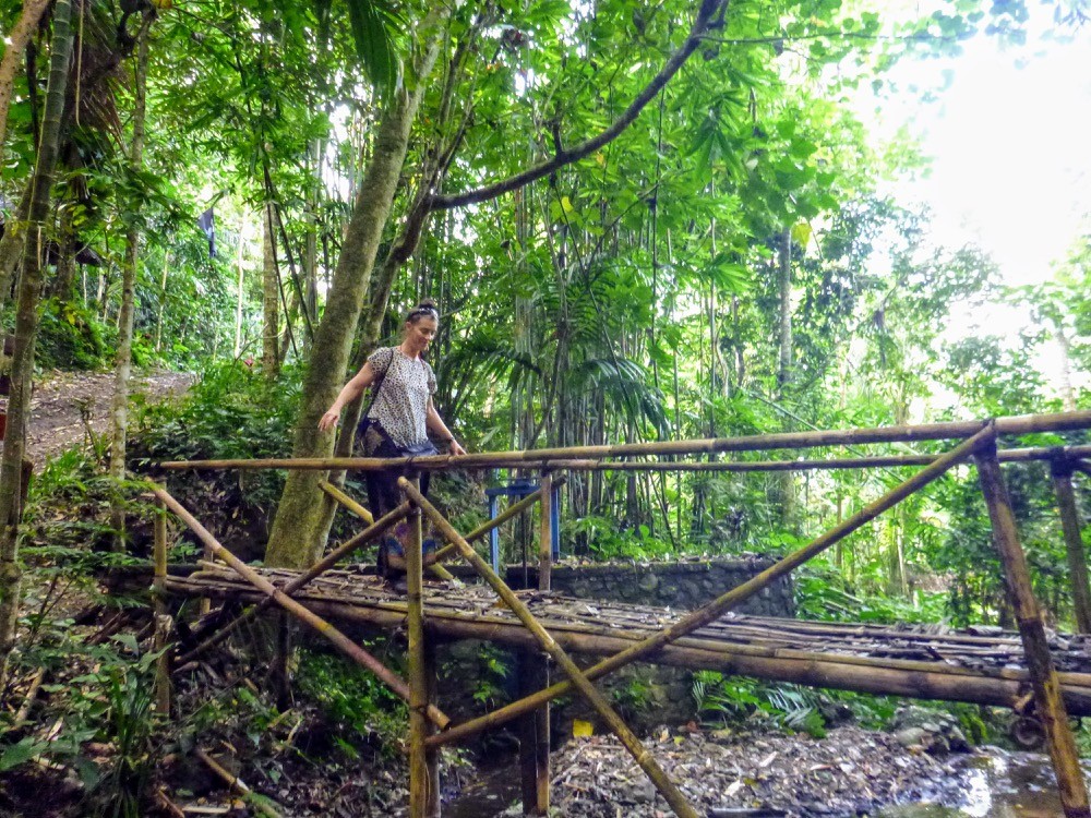 AdventureGirl Andrea Crossing Old hand made bridge in Bali Indonesia